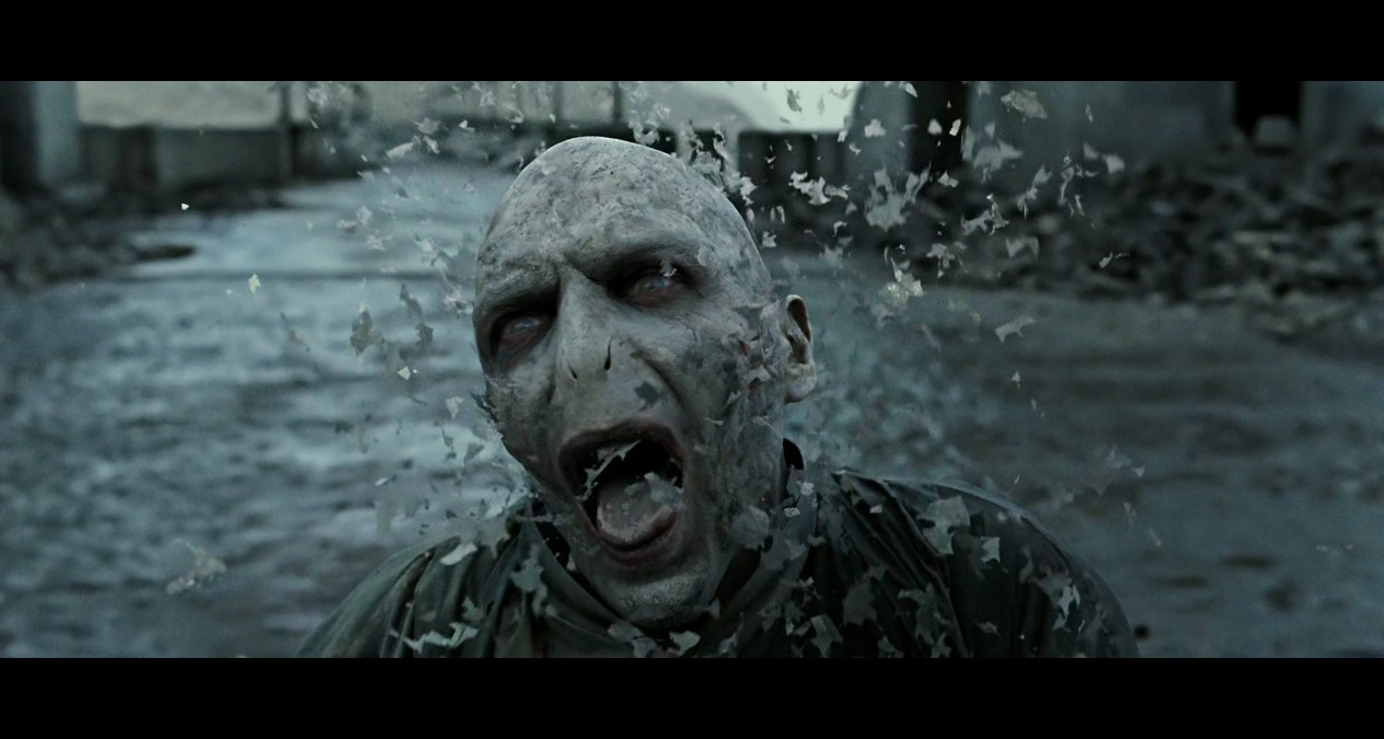 La muerte de Voldemort: En los libros, Voldemort muere como cualquier humano tras perder el control de la Varita de Saúco. En las películas, su cuerpo se desintegra en cenizas, añadiendo un dramatismo visual que no está en el texto.(Crédito: Warner Bros.)